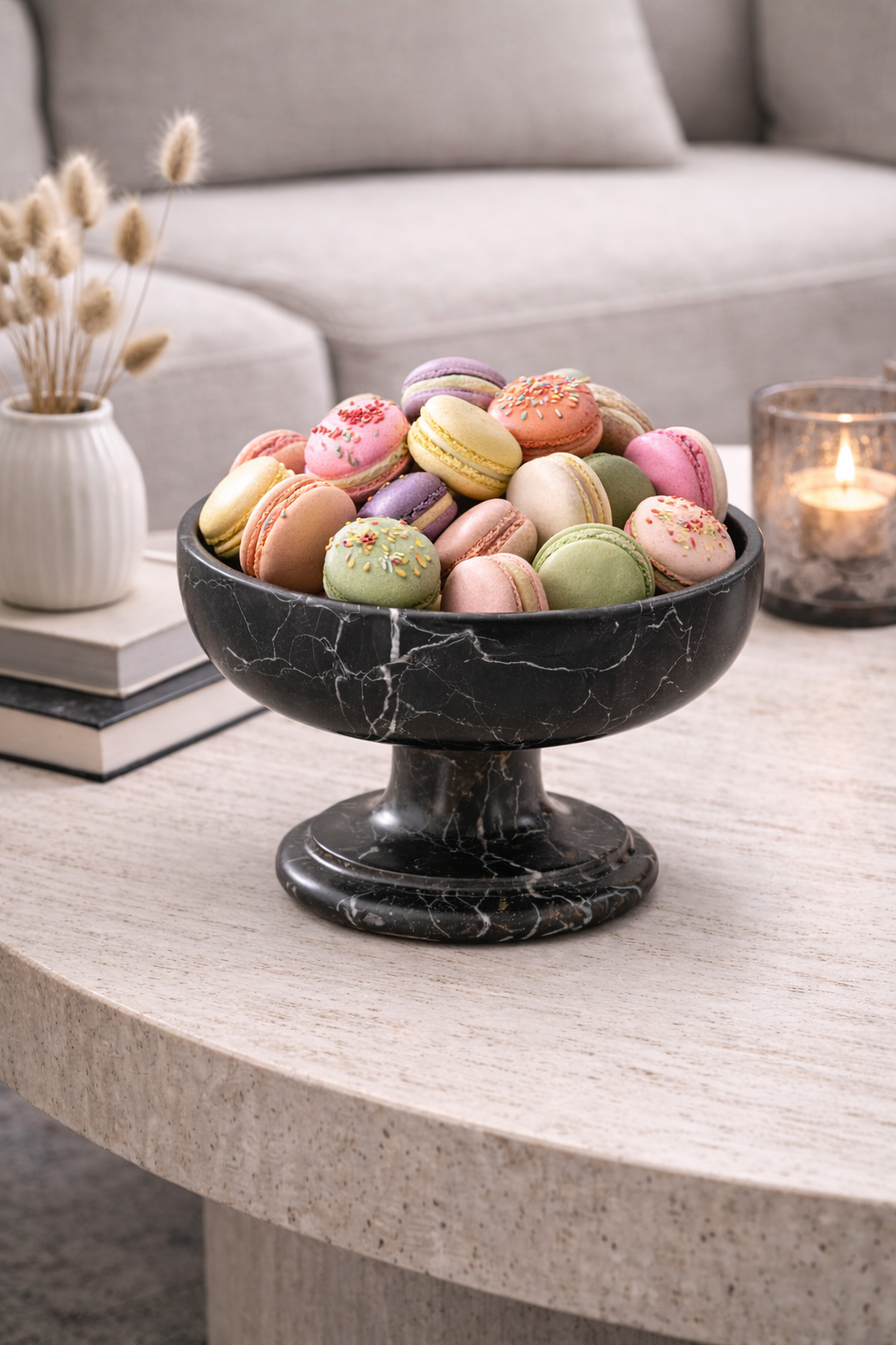 Colorful macarons in a black marble bowl on a table with a blurred background
